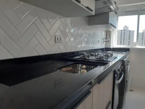 Bancada em granito preto com cooktop e cuba de inox, parede em espinha de peixe
