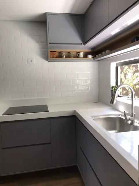 Bancada em L branca com cuba de inox e cooktop por indução