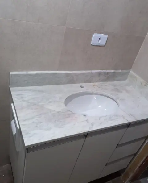 Lavatório em mármore claro com cuba oval embutida