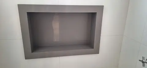 Nicho cinza embutido na parede do banheiro